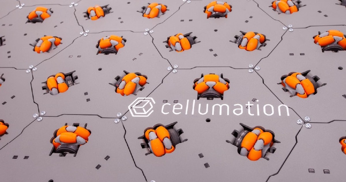 Fotografía oficial de la superficie celluveyor, formada por módulos hexagonales grises con ruedas omnidireccionales naranjas y el logotipo de cellumation.